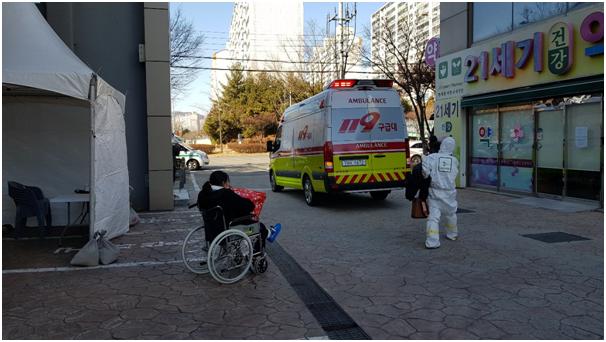 5일 오전 11시35분쯤 광주광역시 운남동 21세기병원에서 신종 코로나바이러스 18번째 확진자(왼쪽)와 119구급요원이 구급차에 탑승하기 위해 이동하고 있다. 광주=김민호 기자