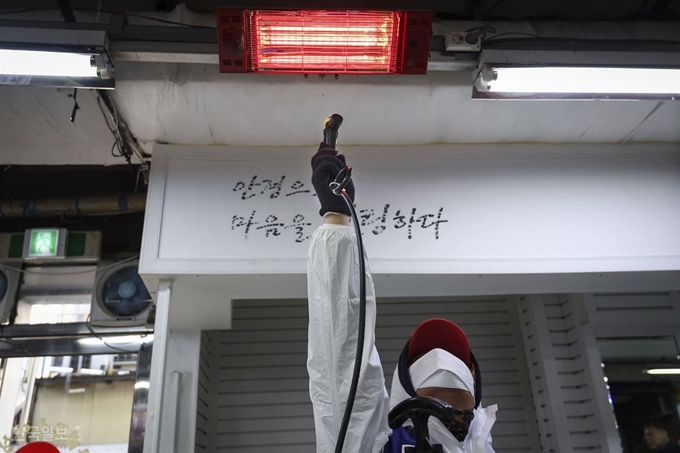 한국방역협회 서울특별시지회 소속 작업자가 5일 오전 신종 코로나바이러스감염증 확산 방지를 위해 서울 중구 남대문시장에 대한 방역을 실시던 중 한파로 인해 소독액이 얼어 붙자 천장에 설치된 전기난로 열기에 소독 장비를 녹이고 있다. 이한호 기자