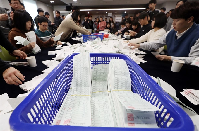 5일 오후 인천시 미추홀구 인천시선거관리위원회에서 열린 제21대 국회의원선거 비례대표 수작업 개표 시연회에서 인천선관위 관계자들이 개표를 시연하고 있다. 앞에는 정리된 모의 비레대표 투표용지가 놓여 있다. 연합뉴스