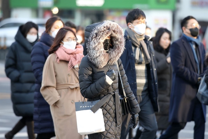 연일 한파가 기승을 부리는 6일 오전 서울 종로구 광화문 네거리에서 두꺼운 외투와 마스크를 착용한 시민들이 발걸음을 옮기고 있다. 연합뉴스