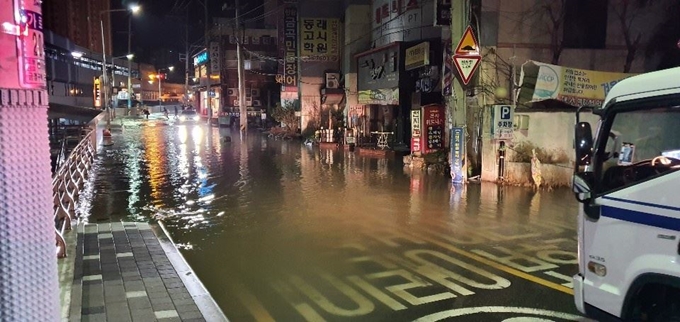 7일 오전 부산 금정구 부곡동에 있는 한 도로에 매설된 상수도관이 파열돼 장전교 인근 도로 250ｍ 구간이 물바다로 변해 있다. 부산경찰청 제공·연합뉴스