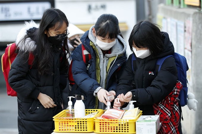 6일 오전 서울 관악구 남부초등학교에서 마스크를 쓰고 등교하던 어린이들이 신종 코로나바이러스 감염증 예방 차원으로 손소독제를 바르고 있다. 뉴스1