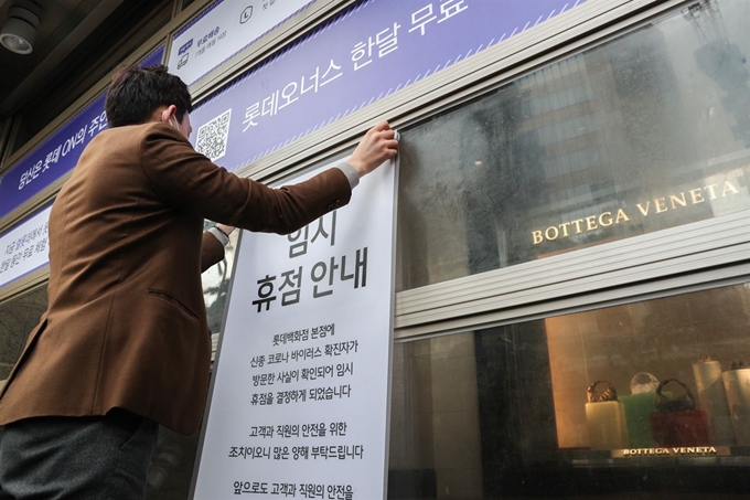 7일 오후 서울 중구 롯데백화점 본점에서 롯데백화점 관계자들이 휴점 안내문을 붙이고 있다. 뉴스1