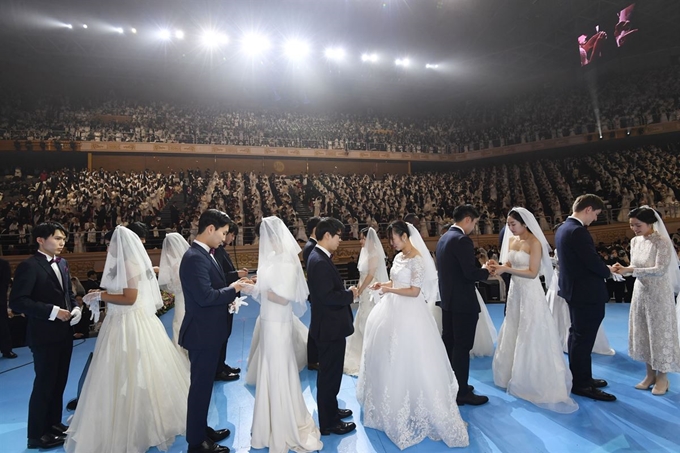 7일 경기도 가평군 평화월드센터에서 열린 '천주성혼 60주년 기념식 및 효정 천주축복식'에서 신랑신부가 예물을 교환하고 있다. 뉴스1