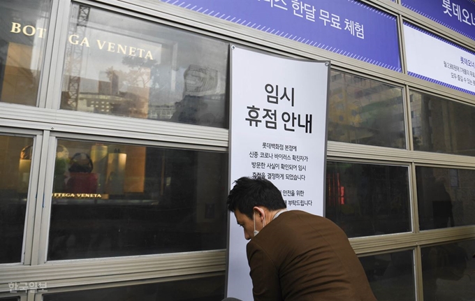 7일 오후 신종 코로나바이러스 23번 확진자가 방문한 것으로 알려진 서울 중구 롯데백화점 본점에서 롯데백화점 관계자가 임시휴업 안내판을 붙이고 있다. 박형기 인턴기자