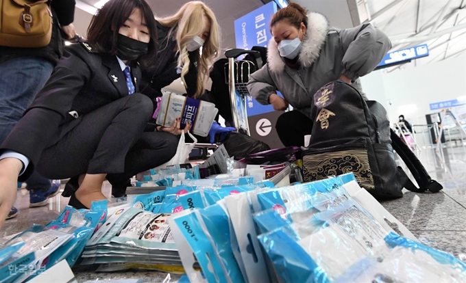 인천국제공항 출국장에서 관세청 직원이 중국인 관광객의 가방 속에서 꺼낸 마스크를 확인하고 있다. 인천=서재훈 기자