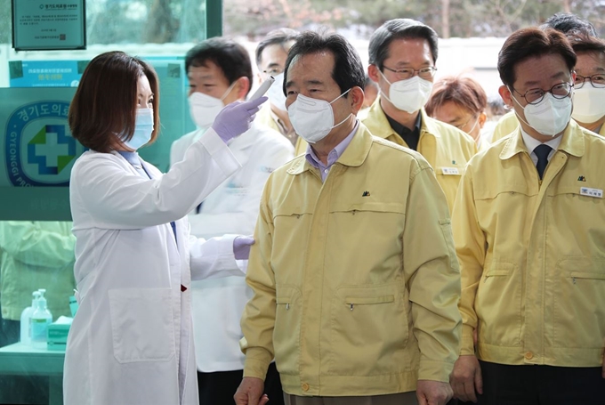 정세균 국무총리가 휴일인 8일 오전 경기도 수원시 장안구의 경기도 선별진료소를 방문해 체온을 측정하고 있다. 오른쪽은 이재명 경기도 도지사. 수원=연합뉴스