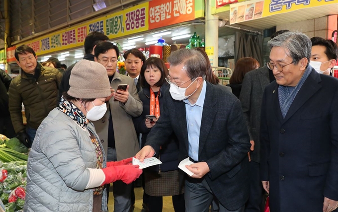 문재인 대통령이 9일 오후 충남 아산시 온양온천 전통시장에서 상인들을 격려하고, 물건을 사고 있다. 연합뉴스.