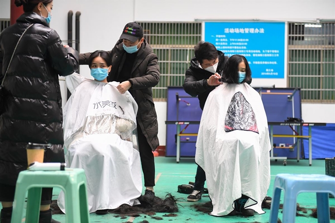 의료진이 8일 중국 후난 성 창사 중앙남대 우한 제3상야병원에서 우한으로 떠나기 전 보호장비를 더 안전하게 착용하기 위해 머리를 짧게 깎고 있다. 창사=신화뉴시스