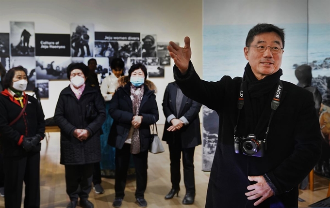 지난 6일 제주 서귀포시 제주국제평화센터 기획전시실에 마련된 ‘제주해녀 사진특별전’ 개막행사에서 양종훈 상명대학교 교수가 사진전을 찾은 해녀들에게 사진을 소개하고 있다. 사진제공=도서출판 윤진.