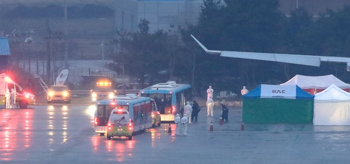 12일 오전 중국 우한 교민을 태운 3차 전세기가 도착하고 있다. 비행기 옆에 임시검역소와 방역복을 입은 관계자들이 분주하게 움직이고 있다. 연합뉴스