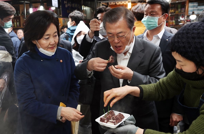 문재인 대통령이 12일 남대문 시장에서 떡을 먹고 있다. 왼쪽은 박영선 중기부 장관. 연합뉴스