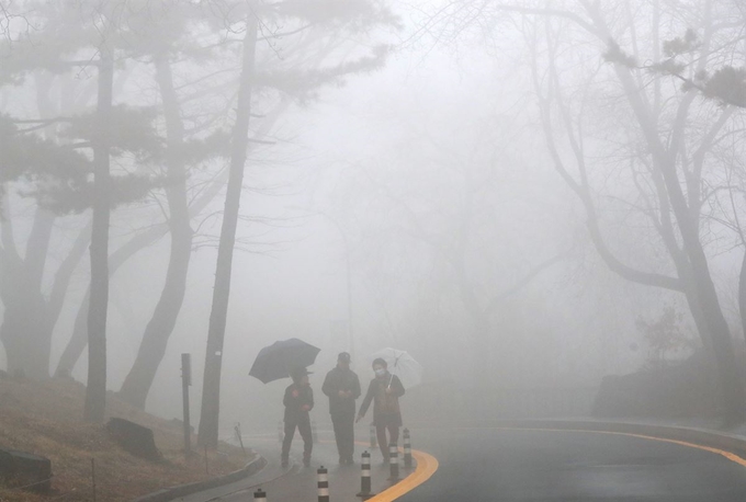 안개가 짙게 깔린 12일 오후 서울 남산을 찾은 시민들이 산책로를 걷고 있다. 연합뉴스