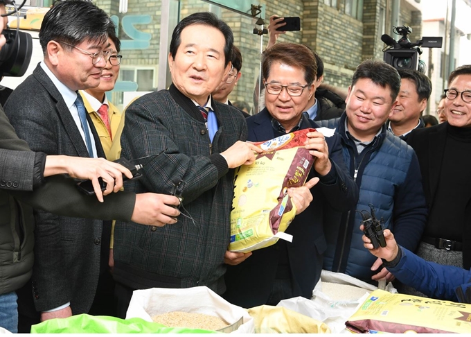 정세균 총리가 13일 우한 교민 임시생활시설로 지정된 경기도 이천 합동군사대학교를 방문한 후 인근 전통시장을 찾아 온누리상품권으로 이천쌀을 구입 하고 있다. 이천=왕태석 선임기자