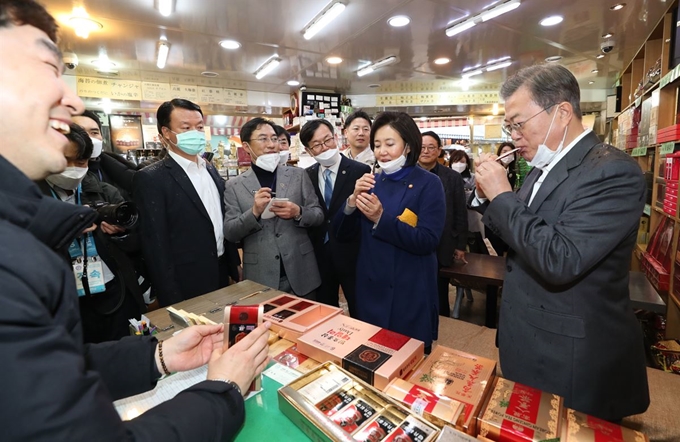 문재인 대통령이 12일 남대문시장에서 스틱형 홍삼액 제품을 시음하고 있다. 문 대통령은 이 제품을 구입, 질병관리본부와 인천공항 검역소에 보냈다고 청와대는 13일 밝혔다. 연합뉴스