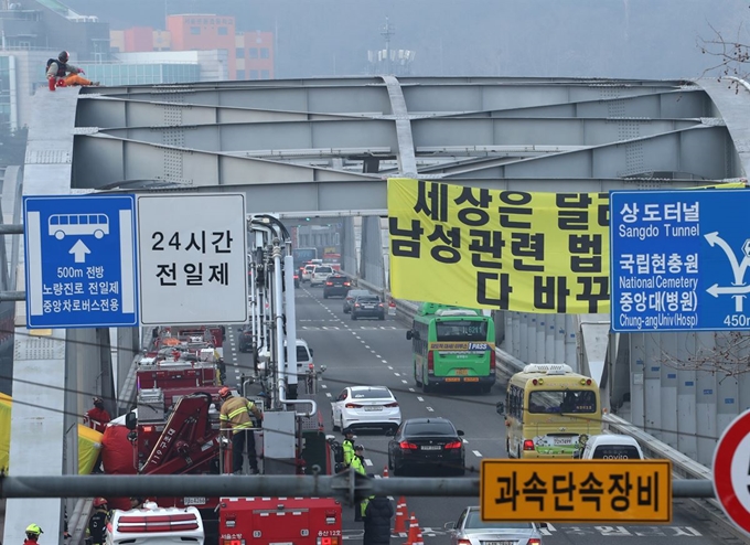 14일 오전 한 중년 남성이 한강대교 아치 위에 올라가 기자들을 불러달라며 시위를 하고 있다. 연합뉴스