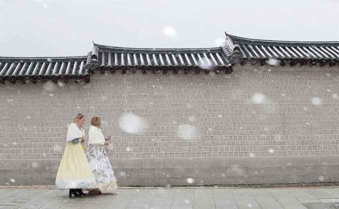 서울에 대설주의보가 내려진 16일 오전 한복을 입고 서울 종로구 경복궁을 찾은 외국인 관광객이 함박눈을 맞으며 이동하고 있다. 연합뉴스,