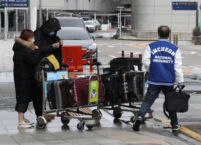 지난 16일 오후 인천국제공항 제1여객터미널 입국장 앞에서 인천대 관계자가 중국인 유학생을 콜밴으로 안내하고 있다. 인천대는 방학 기간 중국에 머물다 들어온 유학생들을 콜밴을 이용해 학교 기숙사까지 수송하고 있다. 연합뉴스