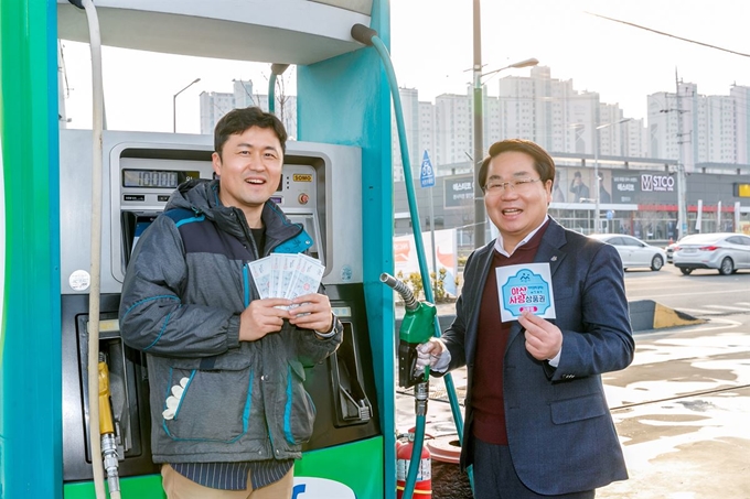 오세현(오른쪽)아산시장이 아산사랑상품권 가맹점으로 신규 가입한 주유소 대표와 기념촬영을 하고 있다. 아산시 제공