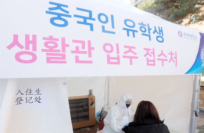 19일 전북 전주 전북대 기숙사 앞에 설치된 중국인 유학생 생활관 입주 접수처에서 한 중국인 유학생이 발열 여부를 검사하고 있다. 전주=뉴스1