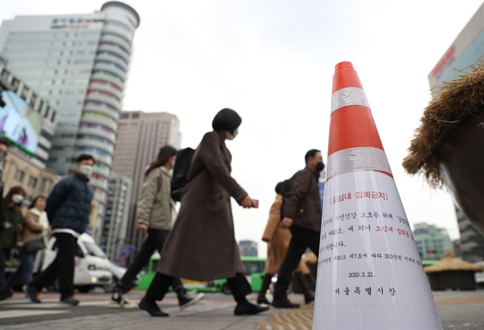 21일 오후 서울 광화문 사거리에 신종 코로나바이러스 감염증(코로나19) 확산 방지를 위해 도심 집회 금지를 알리는 안내문이 교통콘에 붙어있다. 연합뉴스