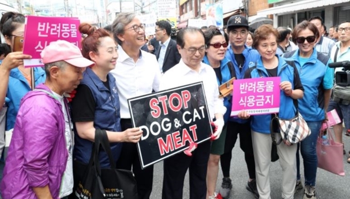 지난해 7월 구포가축시장 폐업 협약식 이후 오거돈 부산시장(앞줄 오른쪽에서 다섯번째)과 전재수 더불어민주당 의원(오 시장 왼쪽옆) 개 식용 반대 손팻말을 들고 있다. 부산시는 구포가축시장이 폐업된 자리에서 올해 7월 동물보호 축제를 개최하겠다고 밝혔다. 연합뉴스