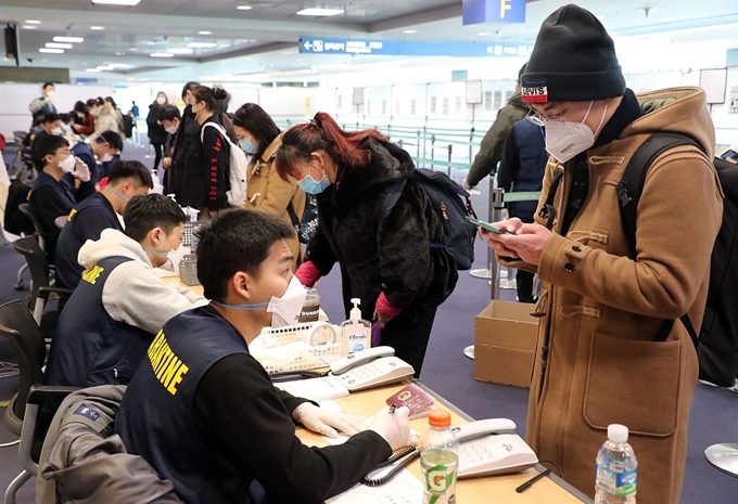 [저작권 한국일보] 신종 코로나바이러스 감염증(코로나19)이 급격하게 확산하고 있는 가운데 24일 인천국제공항 중국 전용 입국장에서 한 중국인 유학생이 신종 코로나 자가 진단 애플리케이션을 설치하고 있다. 서재훈 기자