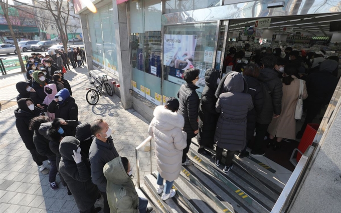 신종 코로나 확진자가 급증하고 있는 가운데 지난 23일 오전 대구 서구의 한 생활용품점에서 시민들이 마스크를 사기 위해 줄을 서 있다. 대구=뉴스1