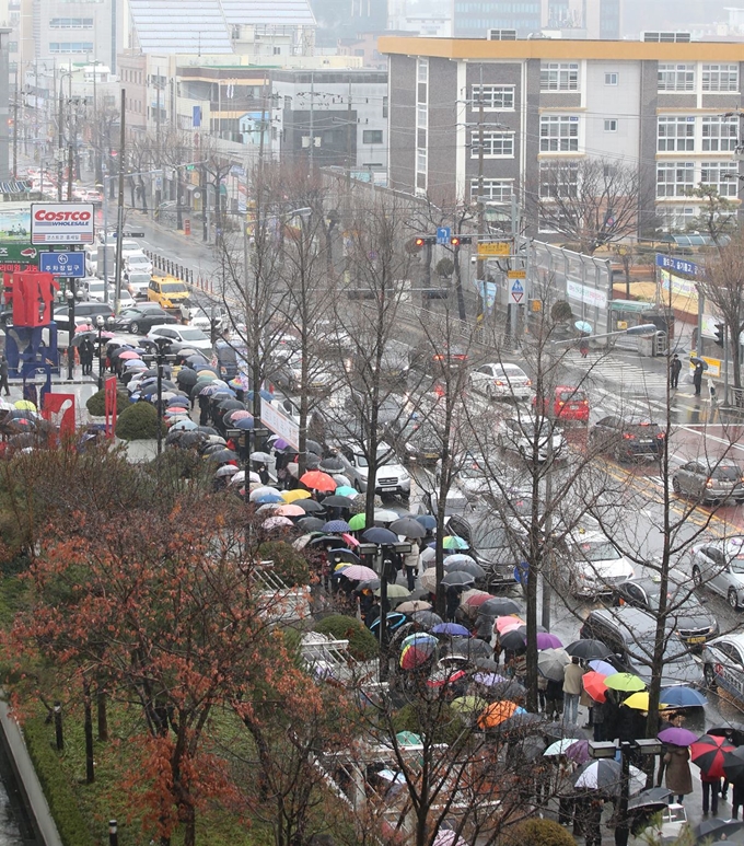 25일 오전 대전 중구 오류동 코스트코 대전점에서 시민들이 우산을 쓰고 마스크를 사기 위해 줄지어 서 있다. 뉴스1