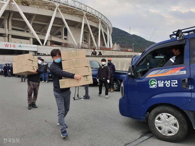 대구 달성군 공무원들이 26일 대구스타디움에서 식품의약안전처가 대구와 경북 청도지역에 보급한 마스크 106만장 중 일부를 트럭에 옮겨싣고 있다. 대구지역 각 구군과 청도군은 이날 마스크를 옮겨 취약계층 등에 배분하게 된다. 김민규 기자 whitekmg@hankookilbo.com