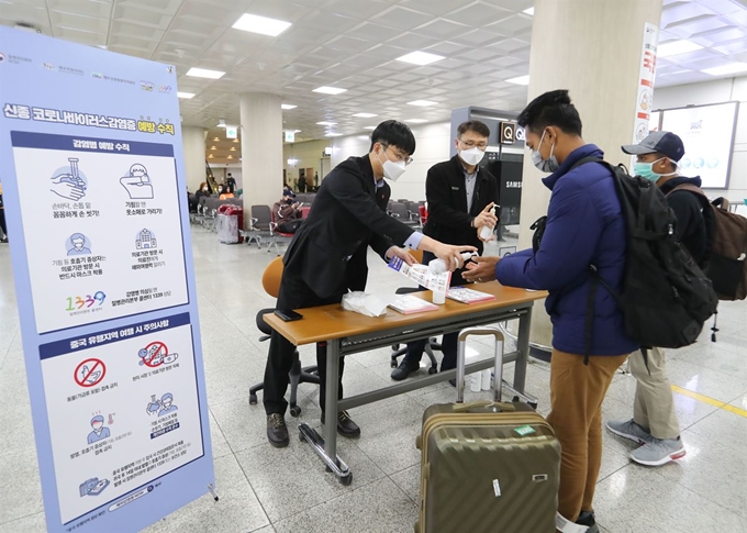 신종 코로나바이러스 감염증(코로나19)이 확산 중인 26일 제주국제공항 1층 대합실에서 보건당국이 공항 이용객들에게 손소독제를 덜어주고 있다. 제주=뉴시스