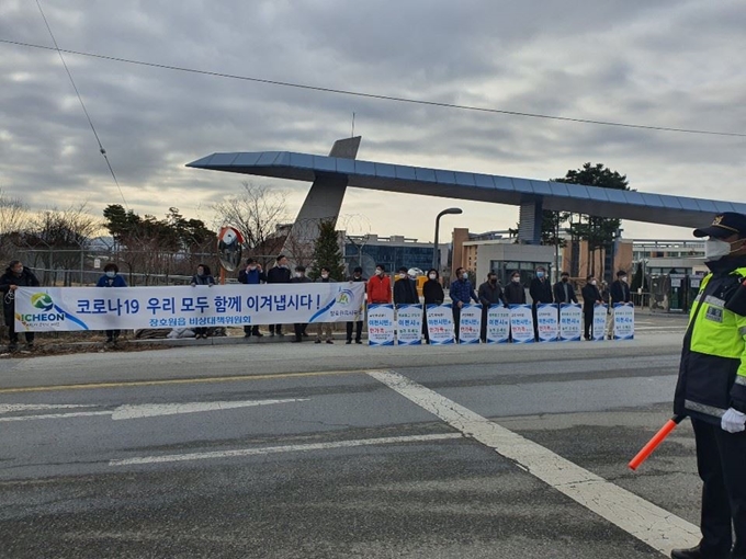 27일 경기 이천 국방대학원 앞에서 주민들이 퇴소를 축하는 내용의 손팻말을 들고 서 있다. 이종구 기자