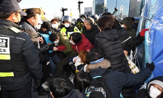 종로구청 철거반원들이 27일 오전 광화문 정부서울청사 인근에 설치된 고 문중원 기수 시민대책위원회 천막 농성장에서 경찰이 지켜보고 있는 가운데 대책위 관계자들을 끌어내고 있다. 왕태석 선임기자