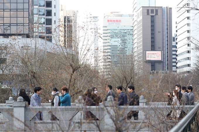 신종 코로나바이러스 감염증(코로나19)의 여파로 27일 서울 종로구 장동교 일대에서 마스크를 착용한 직장인들이 점심시간을 보내고 있다. 연합뉴스