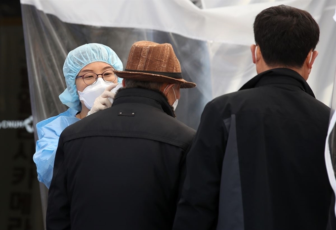 27일 광주 동구 전남대학교병원에서 신종 코로나바이러스 감염증(코로나19) 선별진료소 의료진이 내원한 시민의 발열 체크를 하고 있다. 연합뉴스