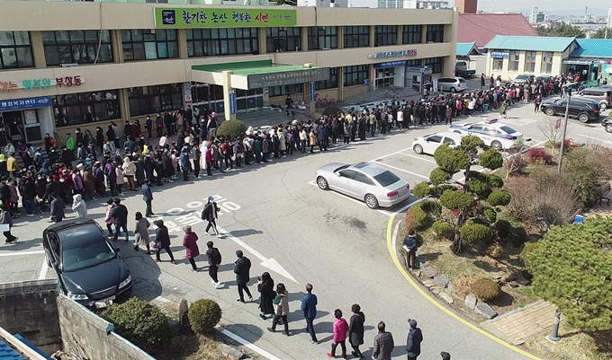 논산시가 27일 한국노텍과 손잡고 마스크를 읍·면·동사무소를 통해 저렴하게 공급하자 시민들이 줄지어 구매 순서를 기다리고 있다. 논산시 제공