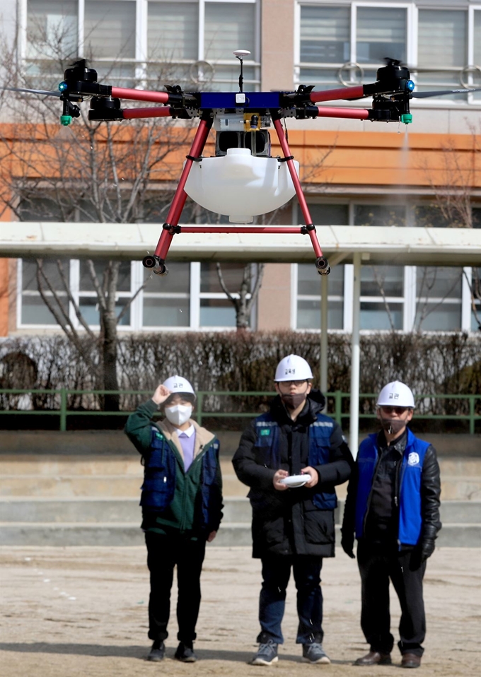 27일 경기도 수원시 장안구 송정초등학교에서 사회적기업 '사람과 자연 협동조합'과 수원농생명과학고 동아리 '더 드론' 학생들이 드론을 이용한 신종 코로나바이러스 감염증(코로나19) 확산 방지를 위한 방역을 하고 있다. 수원=뉴스1