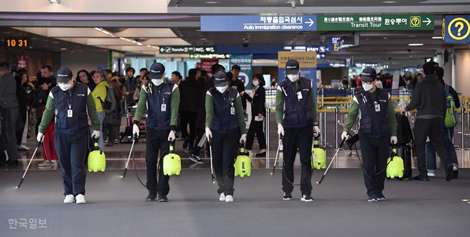 [코로나19] 인천공항공사 시설환경팀 관계자들이 지난달 21일 인천국제공항 입국장에서 방역 작업을 하고 있다. 영종도=이한호 기자