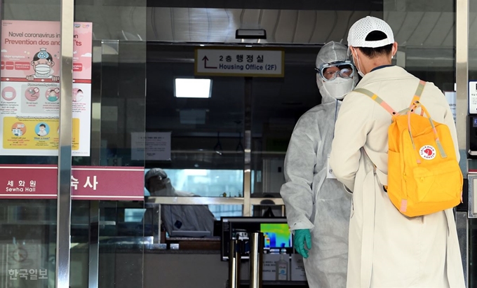 지난달 24일, 한 중국인 유학생이 방역복을 입은 관계자의 안내를 받아 경희대 외국인 기숙사인 세화원으로 들어가고 있다. 배우한 기자