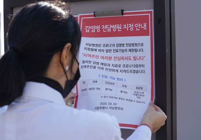 2일 서울시의 코로나19 전담병원인 서울 양천구 서남병원에서 병원 관계자가 진료가능 범위 안내문을 붙이고 있다. 연합뉴스