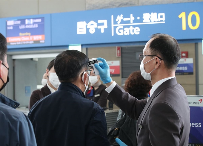 3일 오후 인천국제공항 제1여객터미널 탑승 게이트 앞에서 미국행 항공기 탑승객들이 발열 검사를 받고 있다. 연합뉴스