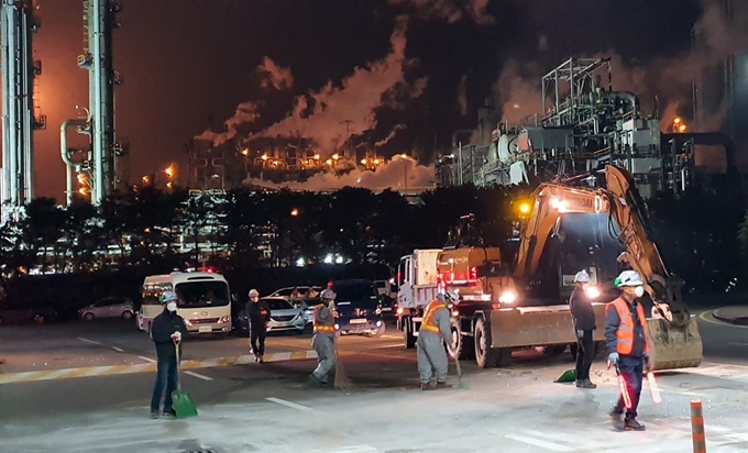 4일 오전 2시 59분쯤 충남 서산시 대산읍 롯데케미칼 대산공장에서 발생한 폭발 및 화재로 떨어진 공장 정문 구조물 파편을 공장 관계자들이 굴착기로 치우고 있다. 연합뉴스.