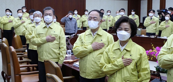 문 대통령이 3일 정부서울청사에서 영상국무회의를 주재하기에 앞서 국민의례를 하고 있다. 대통령을 비롯한 참석자들은 각각 다른 마스크를 착용했는데, 소속 기관에서 일괄 구입한 제품인 까닭으로 보인다. 왕태석 선임기자