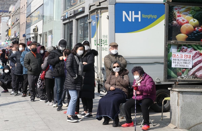 4일 서울 양천구 하나로마트 경서농협신정지점에서 마스크를 사려는 시민들이 줄을 서 있다. 연합뉴스/그림 23일 정부가 정한 마스크 공적 판매처인 서울 양천구 행복한 백화점 앞에서 마스크를 구매하려는 시민들이 대기하고 있다. 연합뉴스