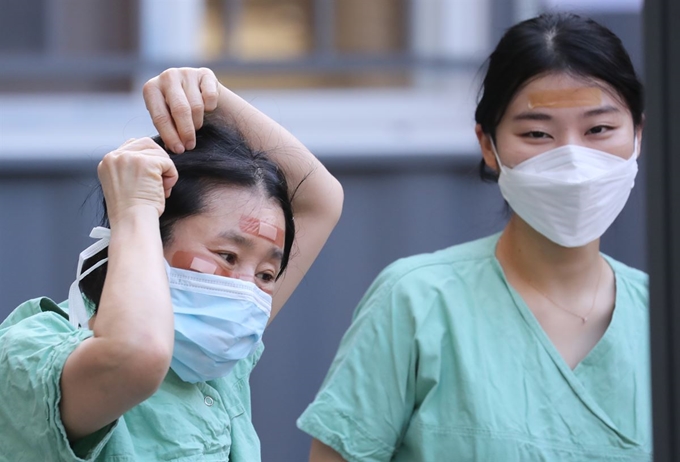 4일 오후 대구 계명대 동산병원에서 신종 코로나바이러스 감염증(코로나19) 확진자 진료를 마친 의료진의 얼굴에 반창고가 붙어 있다. 오랜 시간 보호장구 착용으로 생긴 ‘영광의 상처’다. 대구=연합뉴스