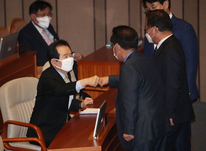 정세균 국무총리가 5일 오후 국회에서 열린 본회의에서 더불어민주당 박용진, 김부겸 의원 등과 인사하고 있다. 연합뉴스