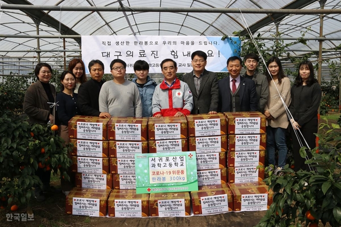 [저작권 한국일보]제주 서귀포산업과학고 학생들이 직접 재배한 한라봉을 대학적십자사 제주지사 관계자에게 전달한 뒤 기념촬영을 하고 있다. 서귀포산업과학고 제공.