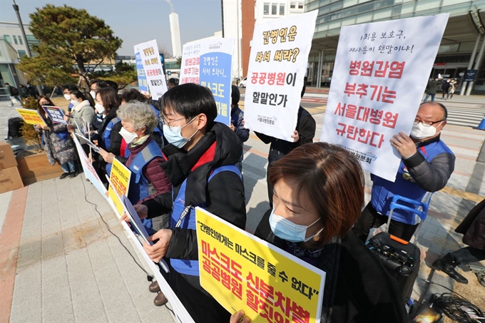 민주노총 공공운수노조 의료연대본부 서울대병원 분회 관계자들이 6일 오전 서울 종로구 서울대병원 앞에서 열린 기자회견에서 간호사, 간병인에게 마스크 지급을 촉구하는 손팻말을 들고 있다. 연합뉴스