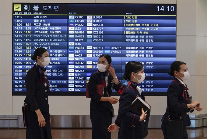 일본 정부가 오는 9일부터 한국과 중국에서 입국하는 자국민과 외국인 모두를 대상으로 2주간 지정 시설 대기를 요청한 가운데 6일 도쿄 하네다 공항에는 마스크를 착용하 항공사 승무원들이 지나가고 있다. 도쿄=EPA 연합뉴스