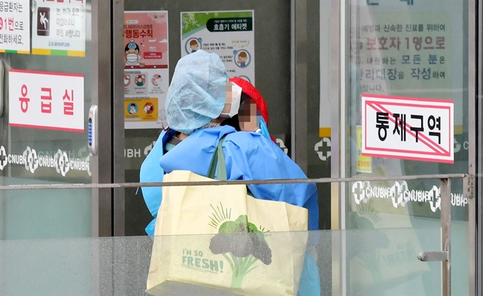 7일 오후 광주 남구 빛고을전남대병원에서 대구에서 온 코로나19 경증 확진자가 어린 자녀를 안고 병원으로 들어가고 있다. 연합뉴스